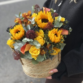Композиция в сумке "Тональность" из подсолнухов, калл, ягод вибирнума, лимонных роз, скиммии и орхидеи в Зарайске