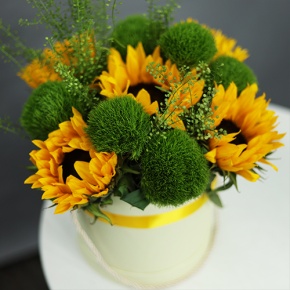 Композиция в шляпной коробке из подсолнухов и диантусов люкс в Зарайске